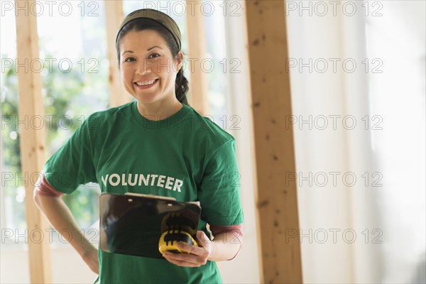 Mixed race volunteer helping build house