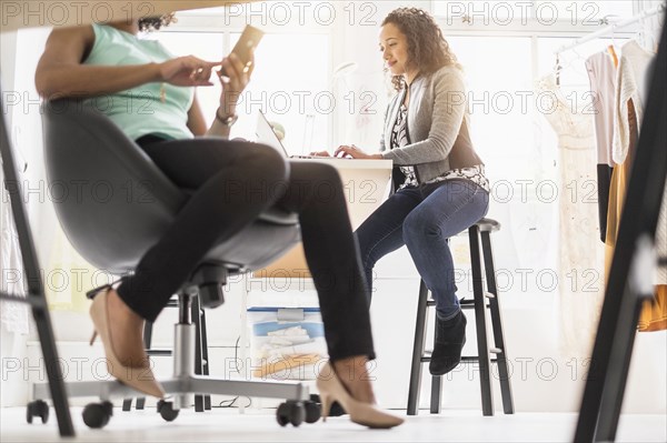 View underneath desk of businesswomen working in office