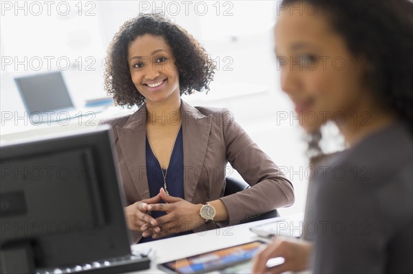 Businesswomen smiling in office meeting