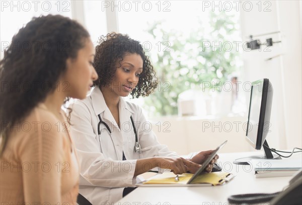 Doctor and patient using digital tablet in office