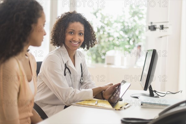 Doctor and patient using digital tablet in office