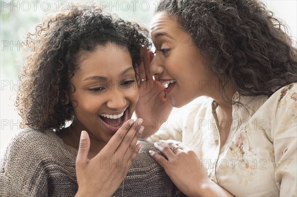 Laughing women whispering secrets