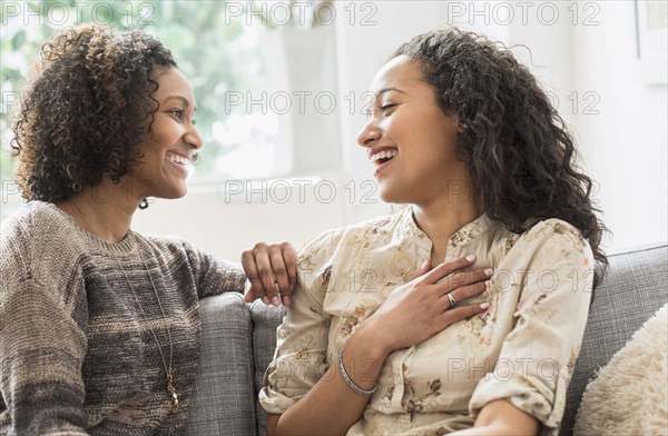 Laughing women talking on sofa