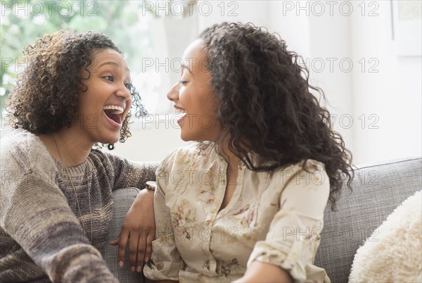 Laughing women talking on sofa