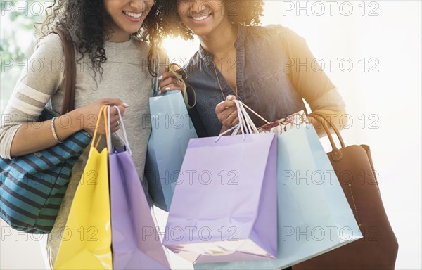 Smiling women carrying shopping bags