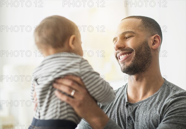 Smiling father holding baby son