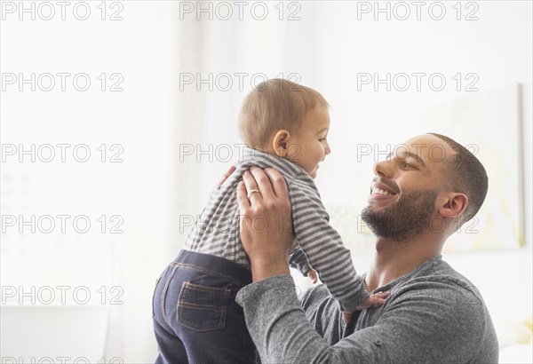 Smiling father holding baby son