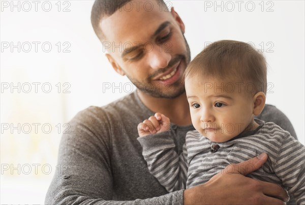 Smiling father holding baby son