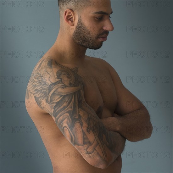 Shirtless Hispanic man with tattoos