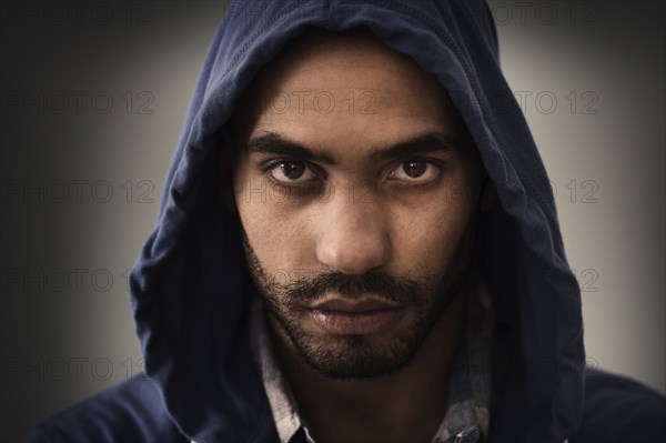 Serious Hispanic man wearing hoodie