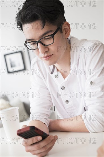 Mixed race man texting on cell phone