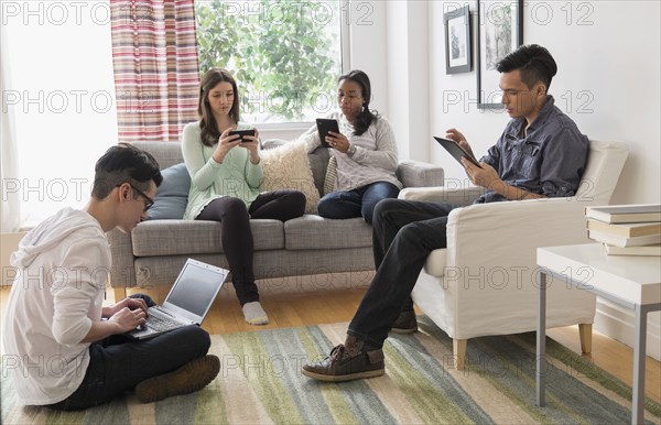 Friends using technology in living room