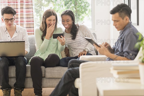 Friends using technology in living room