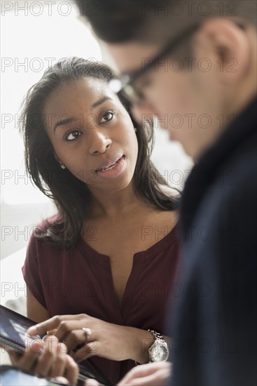 Businesswoman and colleague using digital tablet in office