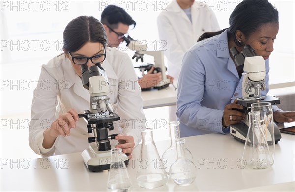 Scientists using microscopes in research laboratory