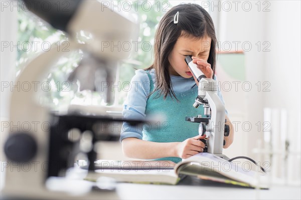 Chinese student using microscope in science lab