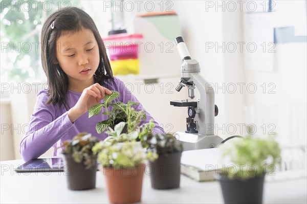 Chinese student examining plants in science lab