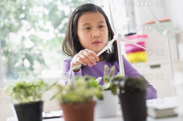 Chinese student examining model wind turbine in science lab