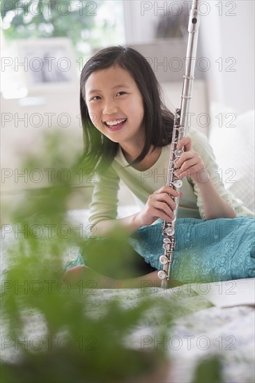 Chinese girl holding flute on bed