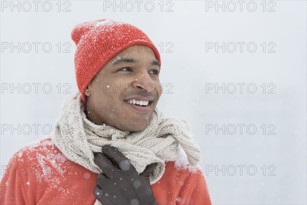 Black man wearing gloves and scarf in snow