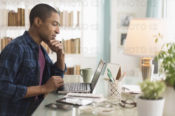 Black businessman working on laptop at desk