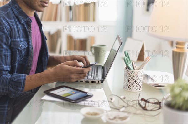 Black businessman multi-tasking at desk