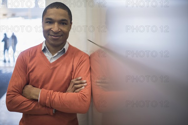 Black businessman smiling near wall