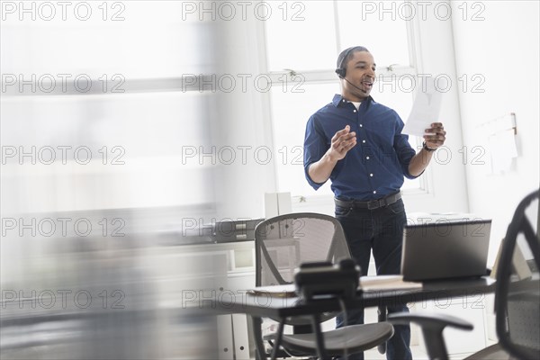 Black businessman talking on headset in office