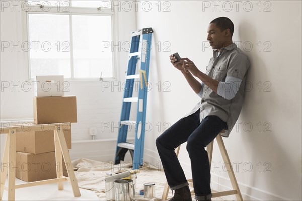 Black man sitting in room under renovation