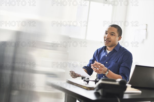 Black businessman talking at office desk