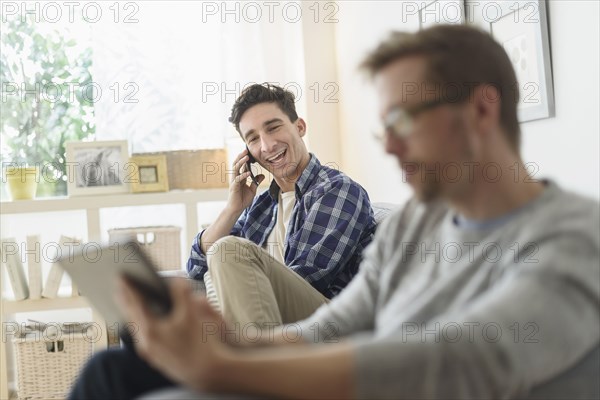 Caucasian gay couple relaxing on sofa