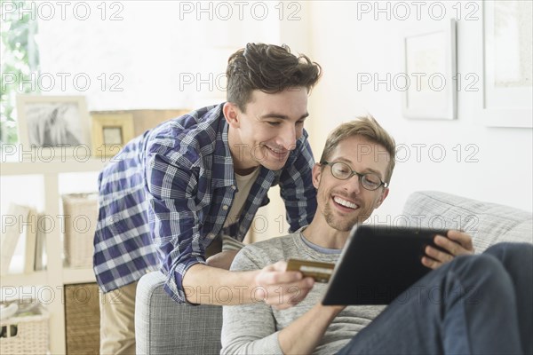 Caucasian gay couple shopping online on digital tablet