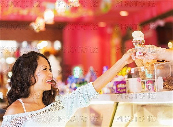 Chinese woman buying ice cream cone in shop