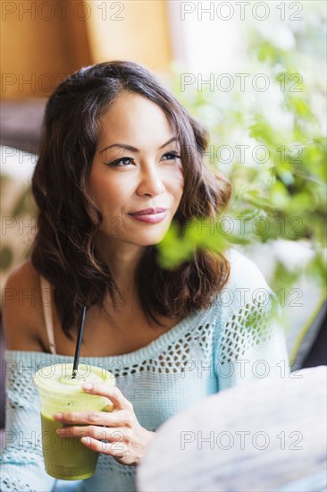 Close up of Chinese woman drinking smoothie