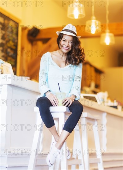 Chinese woman drinking smoothie in cafe