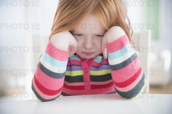 Caucasian girl crying at table