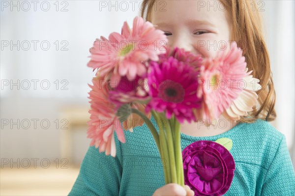 Caucasian girl holding bouquet of flowers