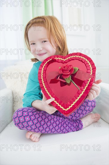 Caucasian girl holding gift box of candy