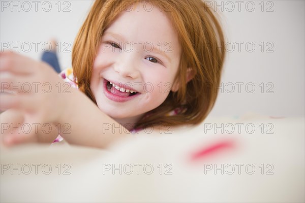 Smiling Caucasian girl laying on bed