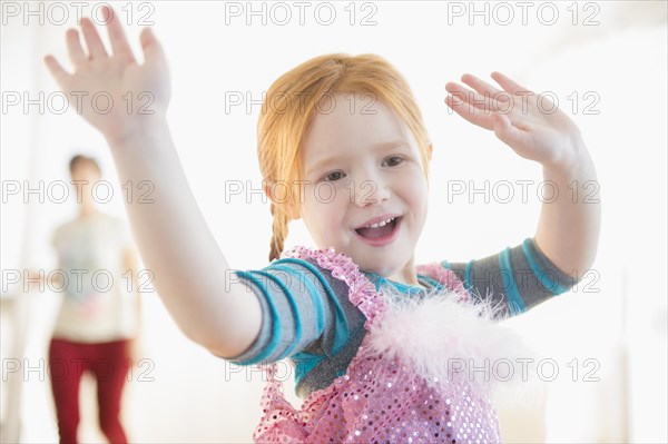 Mother watching Caucasian girl playing dress-up