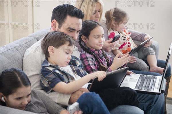 Caucasian family using technology on sofa