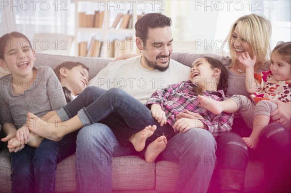 Caucasian family playing on sofa