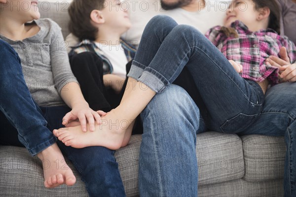 Caucasian father and children relaxing on sofa