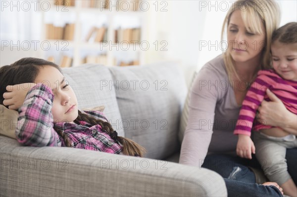 Caucasian mother comforting upset daughter on sofa