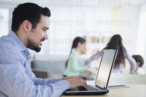 Caucasian man using laptop at desk
