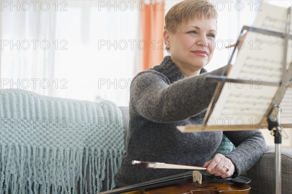 Caucasian violinist writing on sheet music