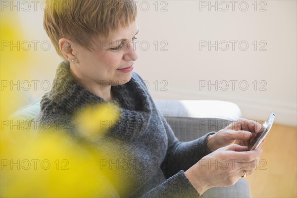 Caucasian woman using cell phone on sofa