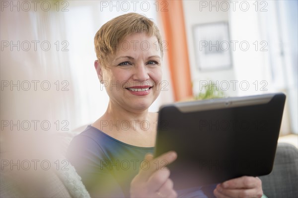 Caucasian woman using digital tablet on sofa