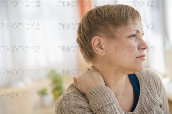 Anxious Caucasian woman rubbing her neck