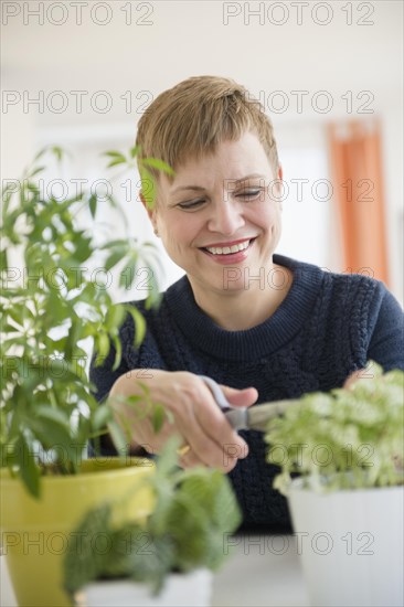 Caucasian woman pruning indoor plants